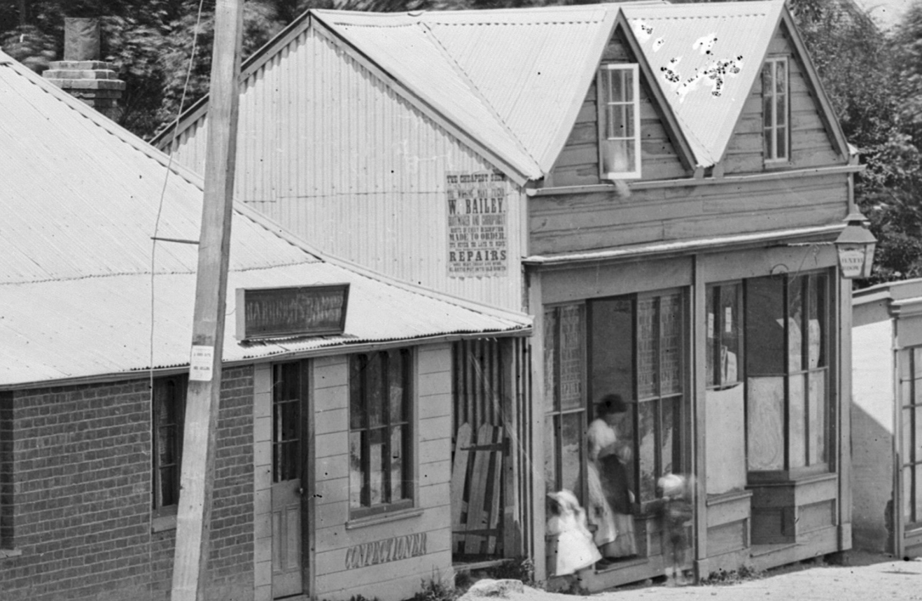 Section of a photo Photo taken by the Burton Brothers on Stafford Street. Te Papa looks to be timber buildings