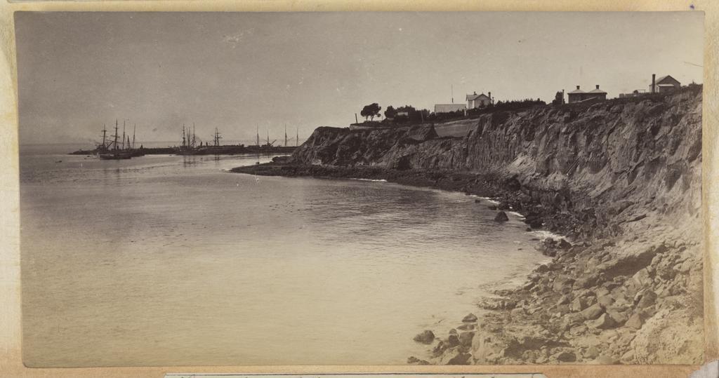 Timaru Caroline Bay rocky cliff area of coastline with the harbour and sailing ships in the distance 14797